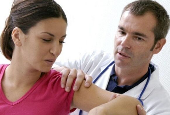 doctor examines shoulder joint with arthrosis